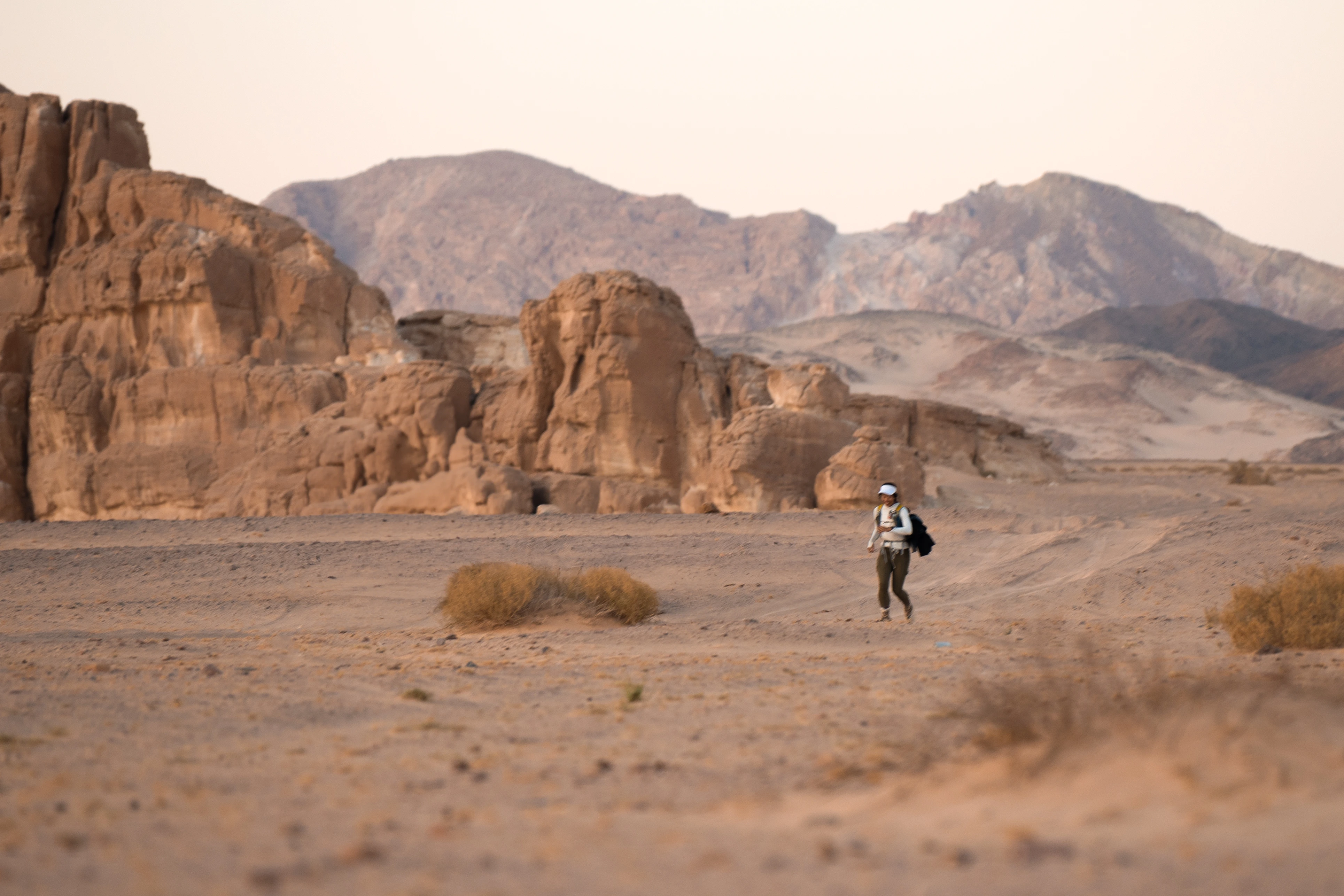 Ria running alone across a vast open landscape, silhouetted against the horizon